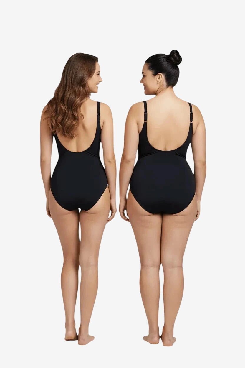 Due donne di spalle indossano un costume intero nero Marette premium dal taglio classico.