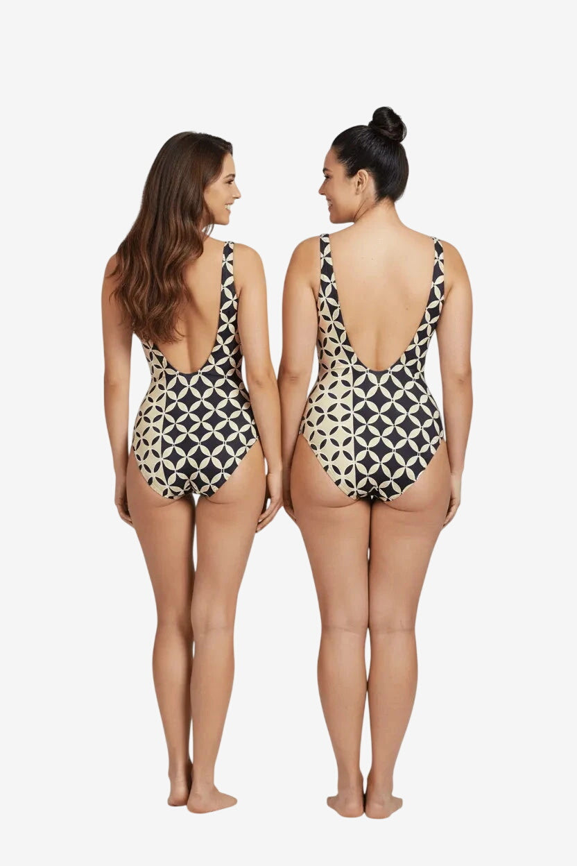 Due modelle indossano un costume intero Roidal con fantasia geometrica color sabbia e nero.