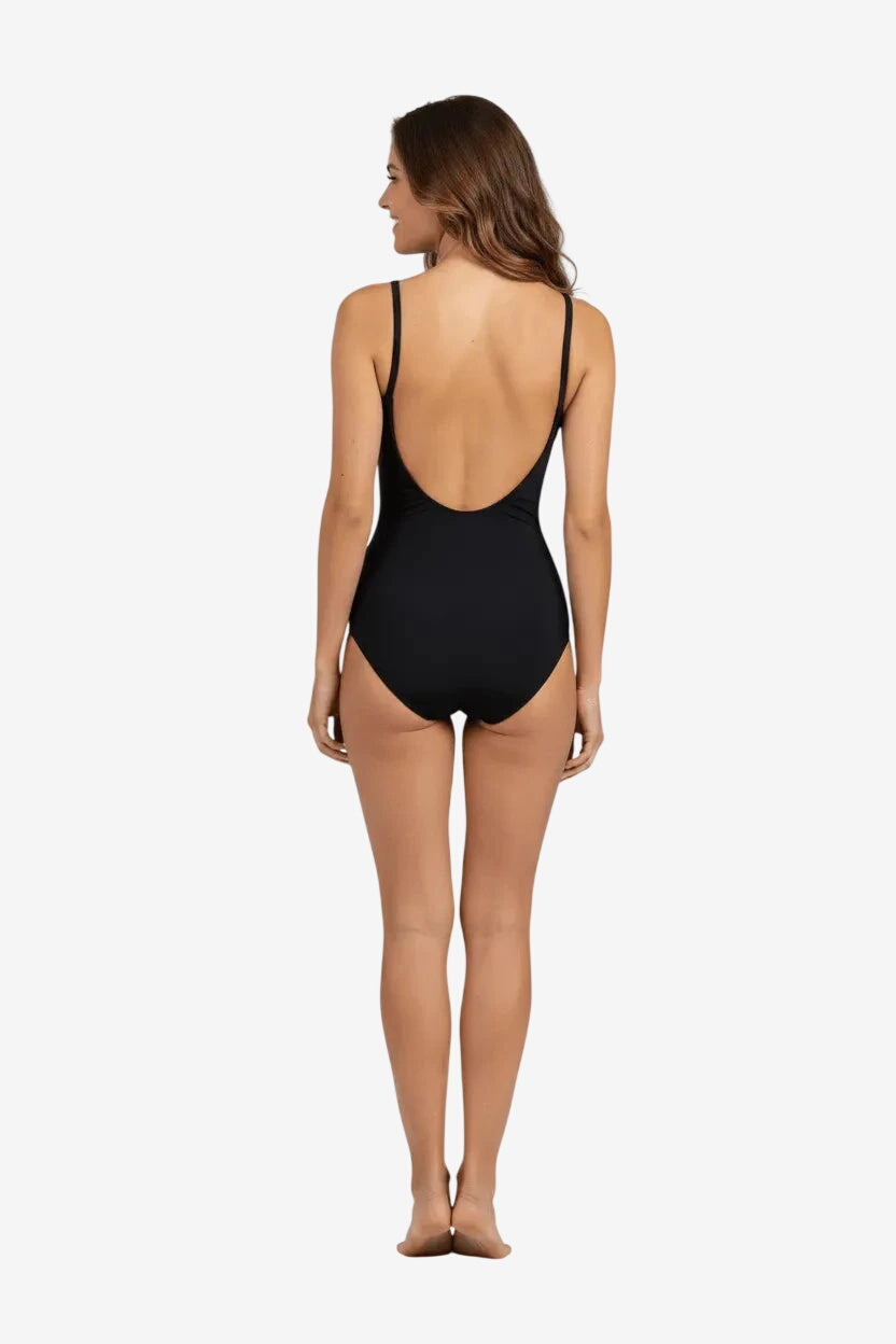 Donna di spalle indossa un costume intero nero dal taglio classico con scollatura sulla schiena.