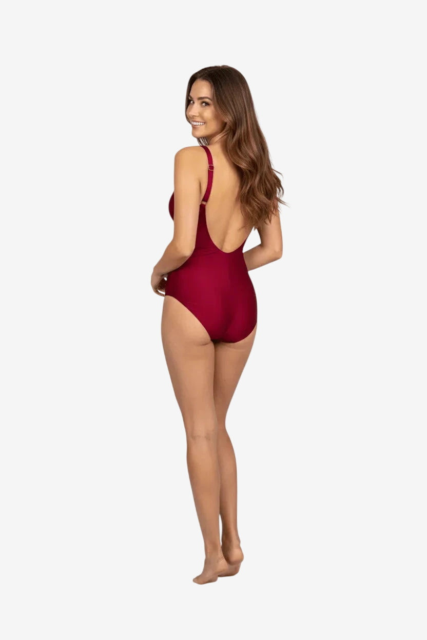 Donna di spalle indossa un costume intero color bordeaux con scollo profondo sulla schiena.
