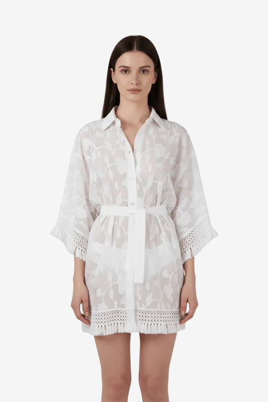 Camicione bianco in tessuto fil coupé con maniche a kimono, cintura in vita e dettagli a frange.