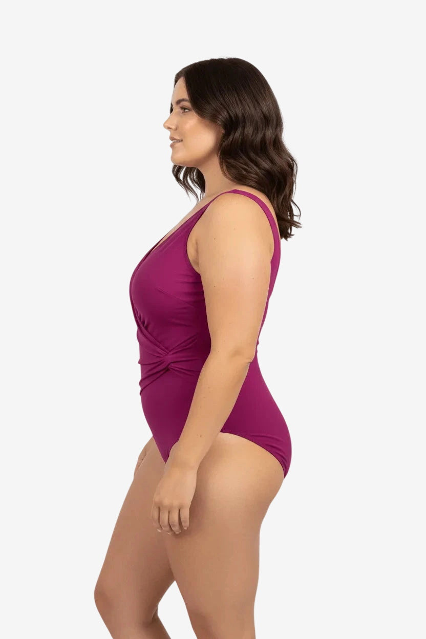 Modella di profilo indossa un costume intero Roidal color bordeaux con dettaglio drappeggiato.
