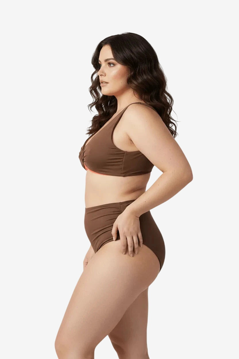 A woman wearing a brown two-piece bikini with a knotted top and high-waisted bottoms.