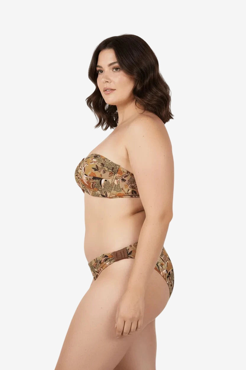 Modella indossa un bikini balconette con stampa floreale nei toni del beige e oro.