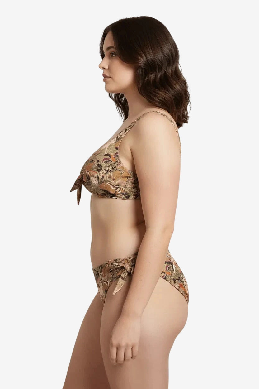 A woman wearing a brown floral print bikini with a tie-front top and side-tie bottoms.