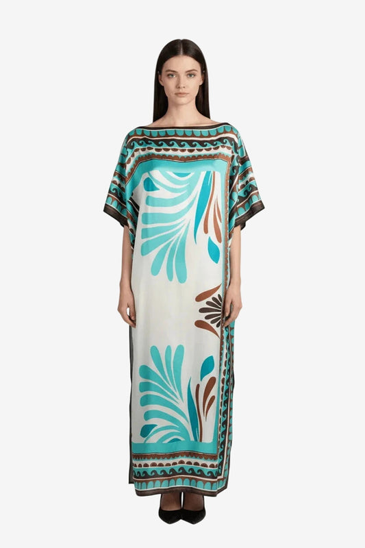Modella indossa un poncho lungo in seta e viscosa con scollo a barca e fantasia tribale azzurra.