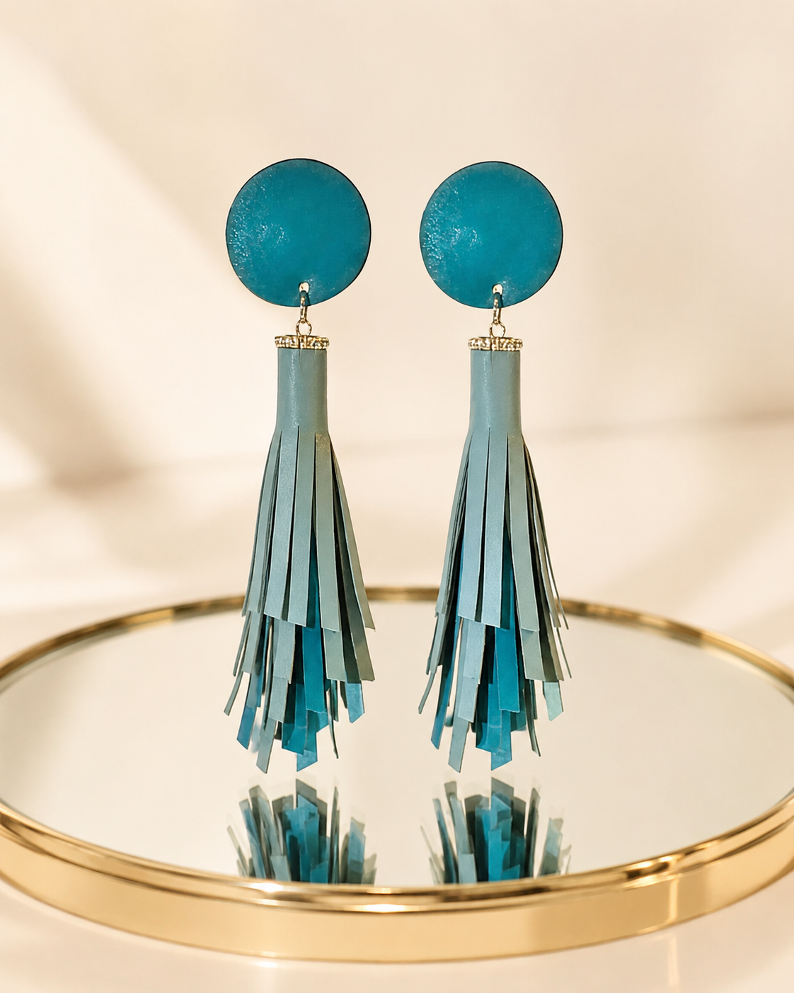 Orecchini pendenti in vera pelle color tiffany composti da un cerchio e una nappa a frange.