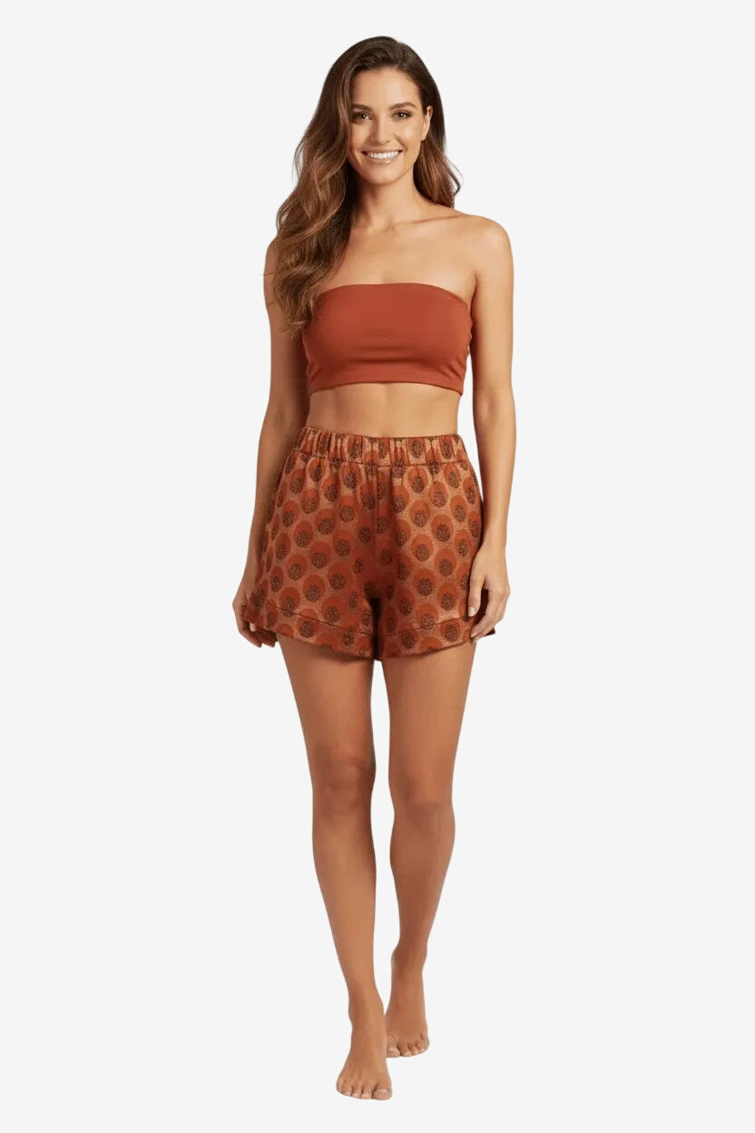 Modella che indossa pantaloncini a vita alta con fantasia a pois color ruggine.