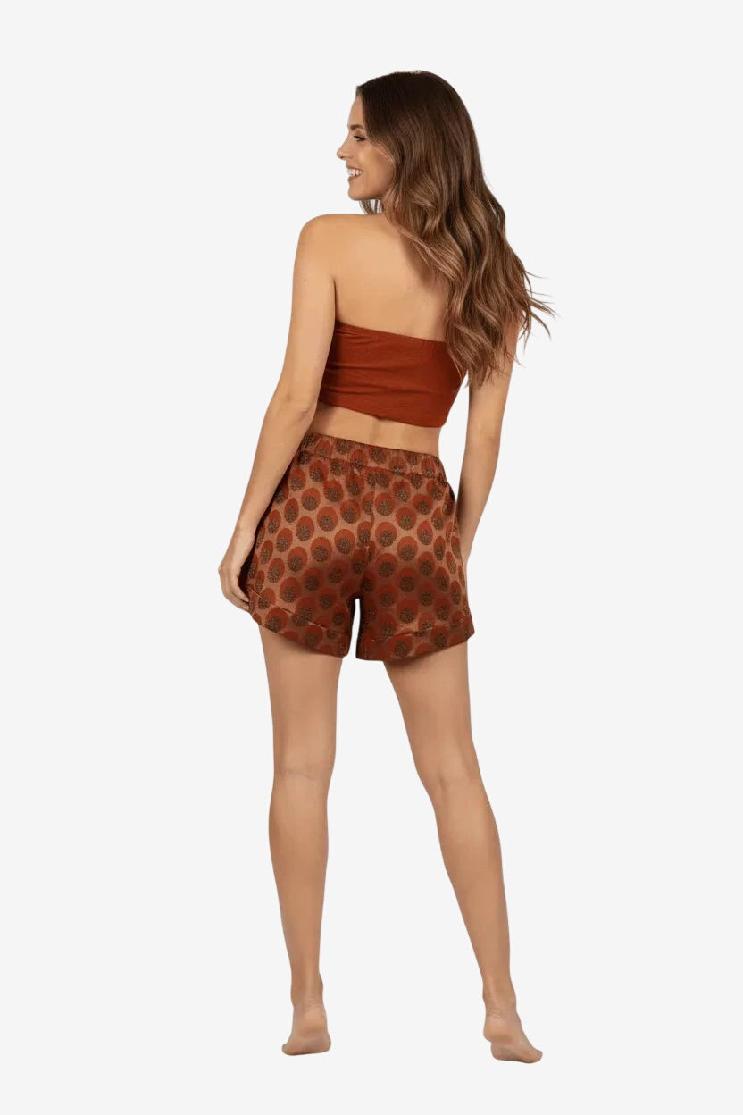 Modella di spalle indossa un pantaloncino marrone a pois con elastico in vita.