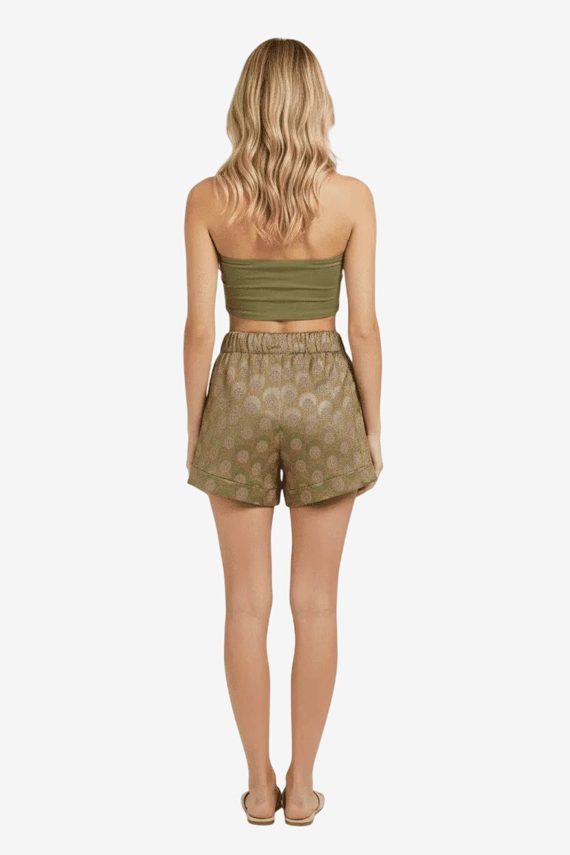 Pantaloncino a vita alta con fantasia a pois su fondo verde, visto da dietro.
