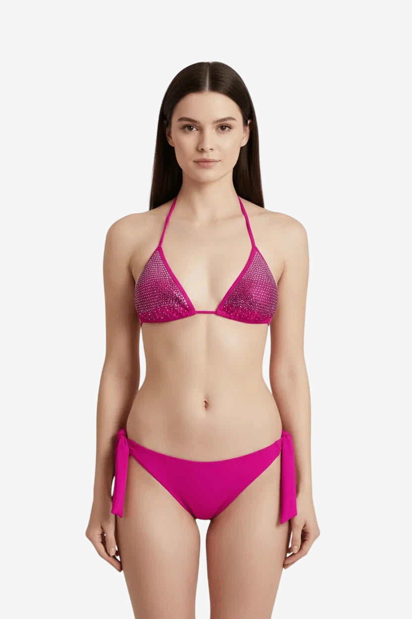 Bikini a triangolo fucsia con decorazioni di strass e slip con laccetti laterali.
