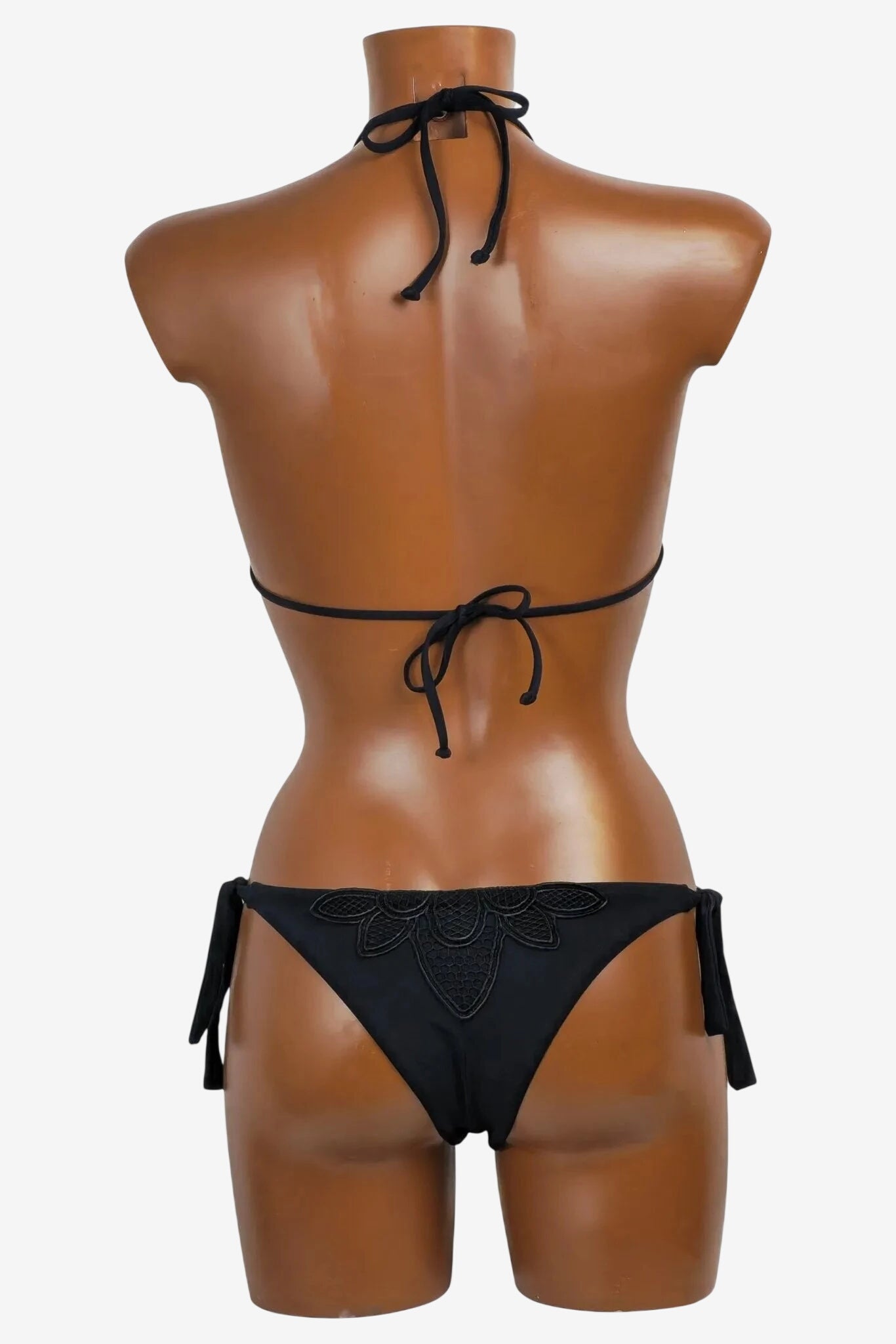 A black bikini set with a triangle top and tie-side bottoms featuring decorative lace detailing.