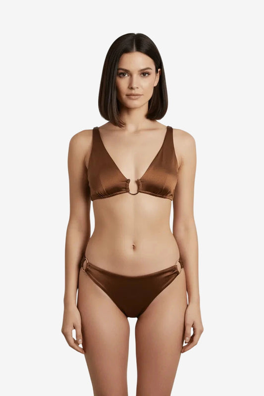 A woman wears a brown satin bikini set featuring gold ring hardware on the top and bottoms.