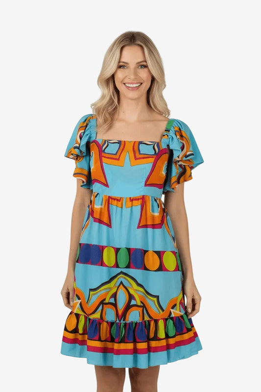 Abito corto azzurro con stampa geometrica colorata, scollo quadrato e volant sulle spalle.