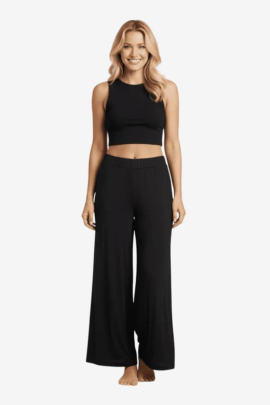 Modella indossa un pantalone palazzo nero in viscosa dal taglio fluido ed elegante.
