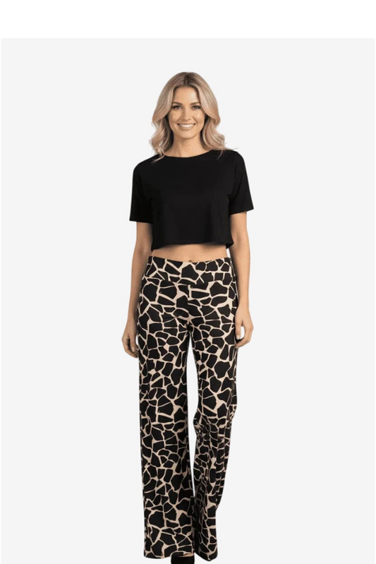 Donna che indossa un pantalone palazzo a gamba larga con stampa animalier giraffa nera e beige.