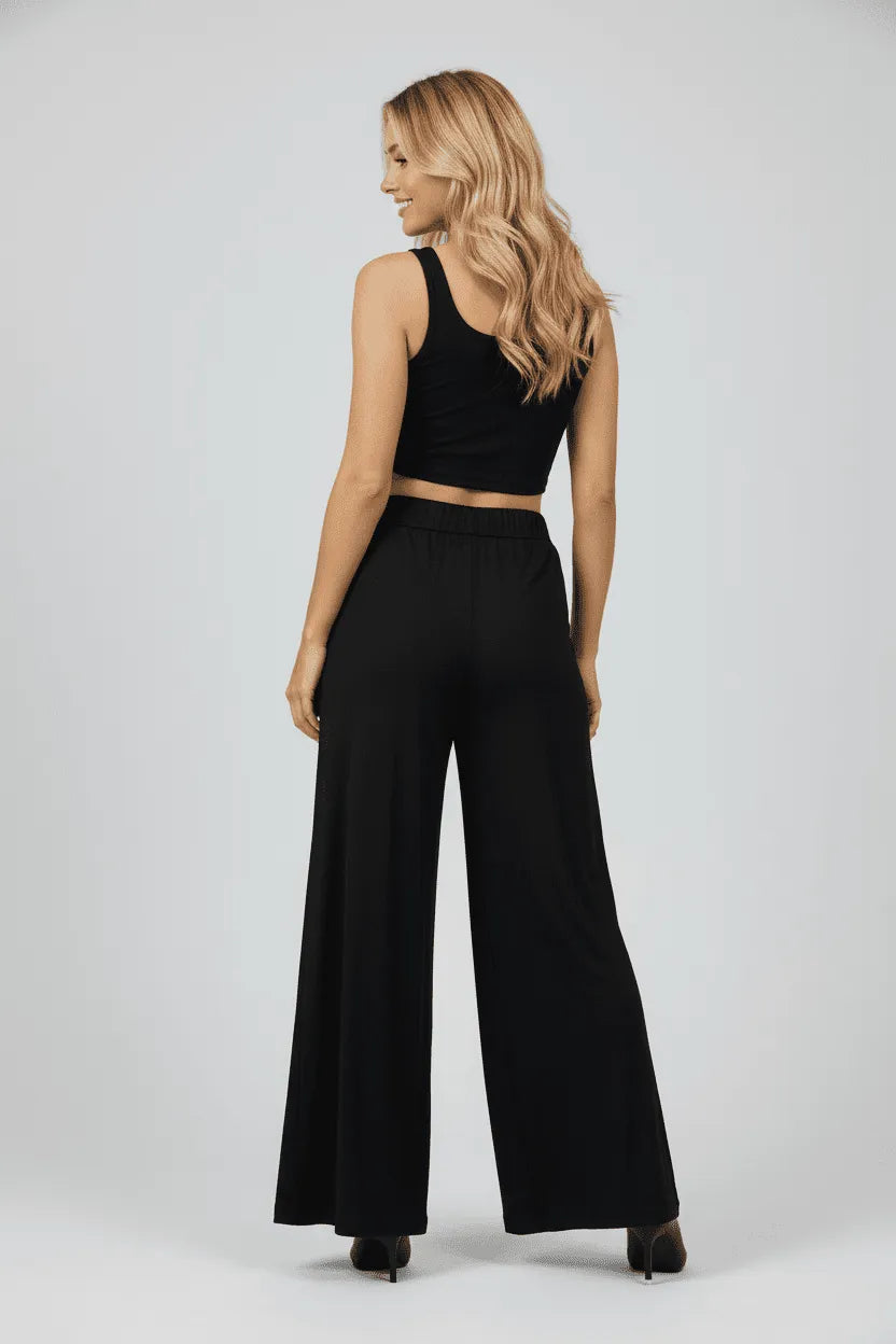 Modella di spalle indossa un pantalone palazzo nero in viscosa dal taglio ampio e fluido.